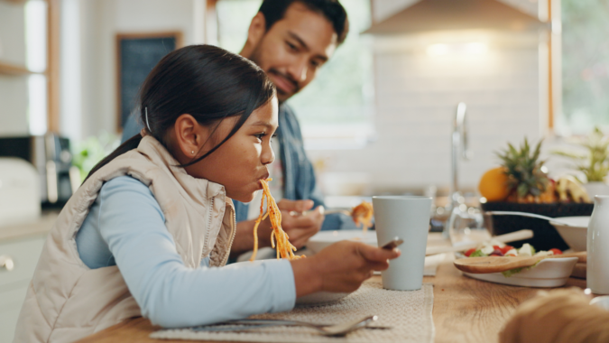 A father and daughter eating a casual meal together.
