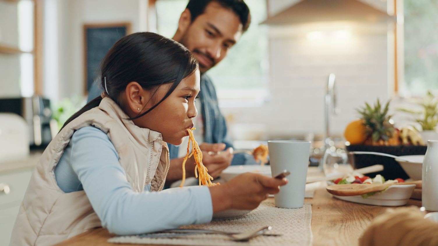 A father and daughter eating a casual meal together.
